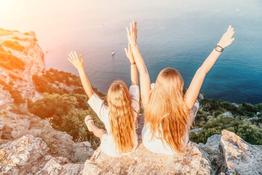 Close up portrait of mom and her teenage daughter hugging and smiling together over sunset sea view. Beautiful woman relaxing with her child.