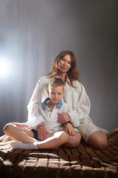 Woman with boy. Mom with son on a white background. Family portrait with mother and boy having fun together