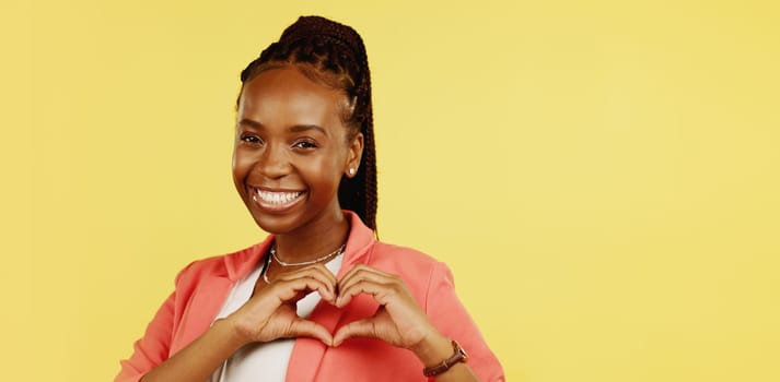 Heart hands, happy and love with black woman in studio for icon, confident and kindness. Gratitude, smile and emoji with girl and positive gesture for support, care and sign isolated on background.