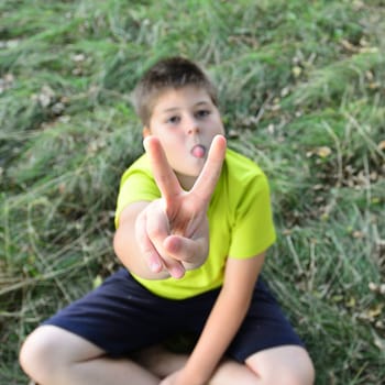Boy showing is a victory sign gesture