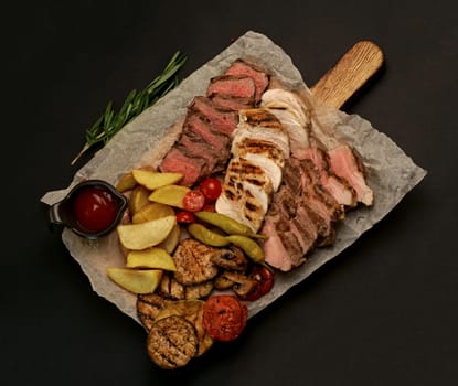 grilled meat. several types of grilled meat cut on a wooden board.