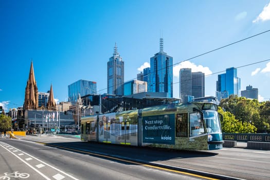 MELBOURNE, AUSTRALIA - OCTOBER 31, 2021: Views towards Melbourne CBD and Princes Bridge with a tram along the Yarra River in Melbourne, Victoria, Australia