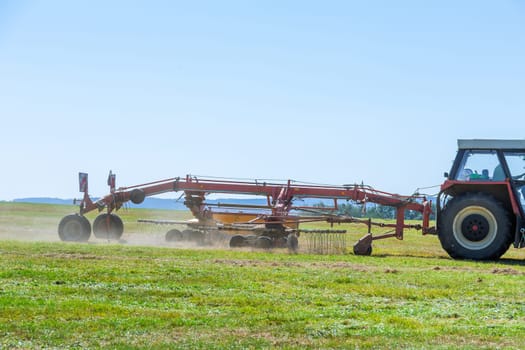 With help of tractor, farmer efficiently baled hay, ensuring good supply for year.