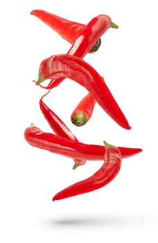 Pods of red hot peppers of various sizes and shapes fall on a white isolated background, casting a shadow. Fresh red pepper for insert in design or project, isolated on white, close up