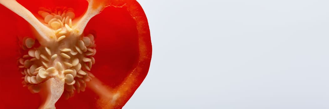 Paprika seeds close-up. A large fresh red paprika is cut in half and its seeds are visible with copy space. High quality photo