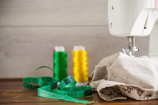 Sewing machine with fabric and threads for sewing, close-up. The working process. Part of a sewing machine with fabric.