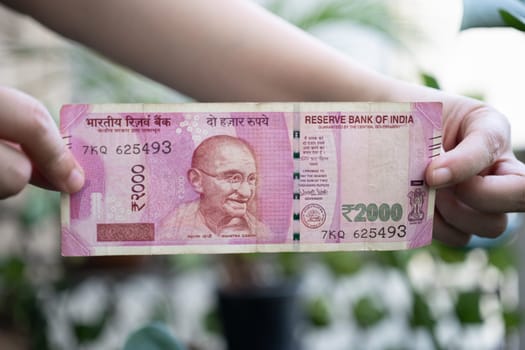 Woman holding a Rs 2000 Indian bank note that has been removed from circulation through demonitization to reduce black money in India