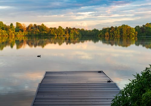 Sunset panorama of the lake shore of the Mere with a perfect lake reflection in Ellesmere in Shropshire