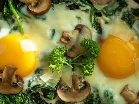 Two eggs with spinach, mushrooms and cheese. Healthy homemade dish for low carb diet. Top view. Macro food. Idea for breakfast.