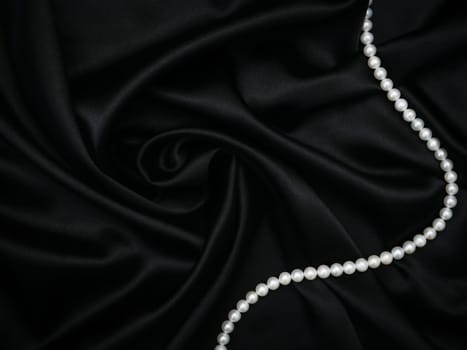 Luxury and sexy concept. Beautiful set of women's evening accessories. Pearl neck and silk black dress. Elegant classic female jewel. Decoration design. Soft focus. Luxury and sexy concept. Party time