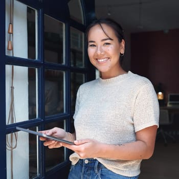 Welcome to my studio. Cropped portrait of an attractive young business owner standing alone at the entrance of her studio and using a tablet