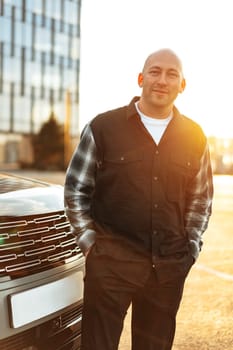 Casual man standing near his luxury car at the parking close up