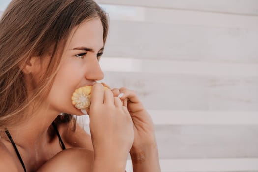 Healthy vegetarian hipster woman in summer outfit eat grilled corn and look to camera. Sexy lady on sea beach sunset or ocean sunrise. Travel, explore, active yoga and meditation lifestyle concept.