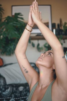 Yoga improves mental and physical health. a young woman meditating while practising yoga at home