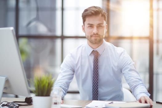 Young cheerful businessman working at office
