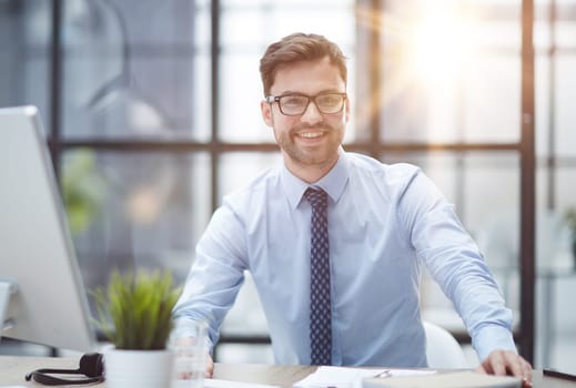 Young cheerful businessman working at office