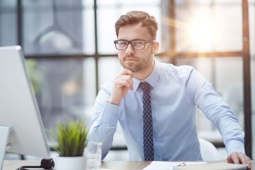 Young cheerful businessman working at office