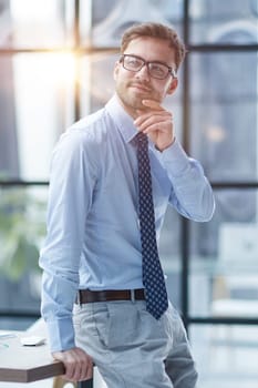 Young cheerful businessman working at office