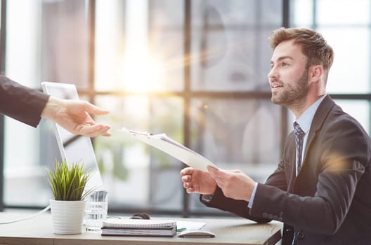Businessman Taking Papers From Secretary In Office