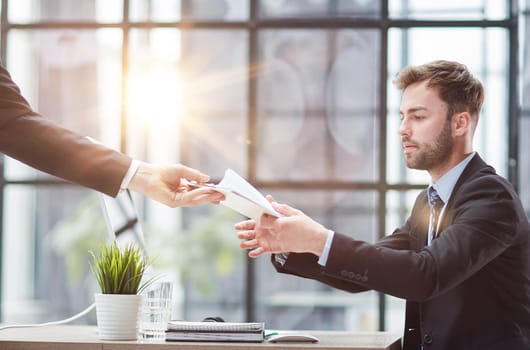 Businessman Taking Papers From Secretary In Office