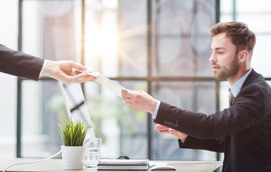 Businessman Taking Papers From Secretary In Office