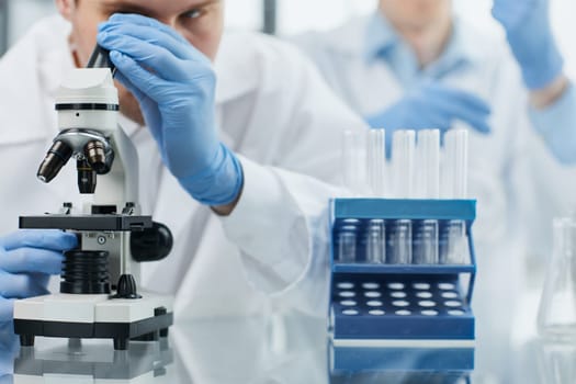 Young scientist looking through a microscope in a laboratory. Young scientist doing some research.