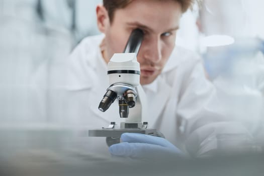 Scientist looks through a microscope in a laboratory. research concept
