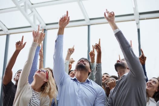 group of diverse young people holding their hands up