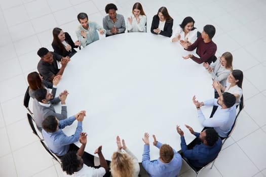 Businessmen or office workers are sitting at a round table in casual clothes.