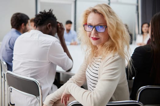 Front view of smiling beautiful businesswoman holding in office