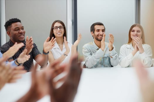 Group of young business workers smiling and clapping to partner at the office