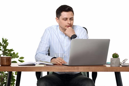 calm entrepreneur man using laptop computer for online work at table on white background