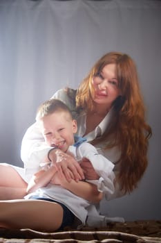 Woman with boy. Mom with son on a white background. Family portrait with mother and boy having fun together