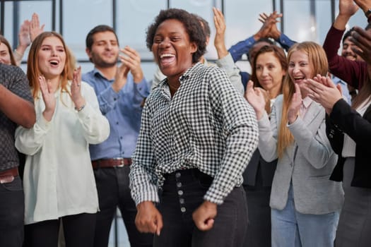 Smiling multiethnic colleagues celebrating common business success or victory in the office.