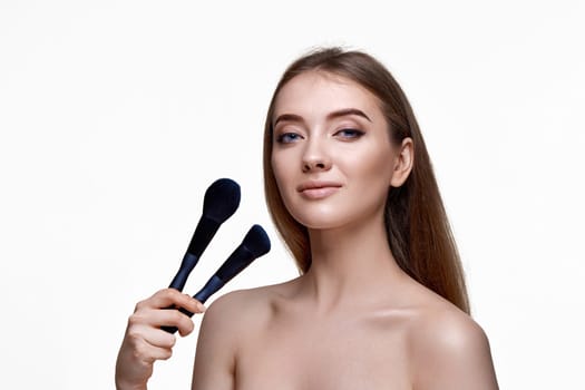 beautiful happy woman with make-up brush for powder isolated on white background. copy space