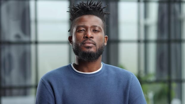Handsome charming cheerful african american businessman in chic colorful casual clothes, in an office building