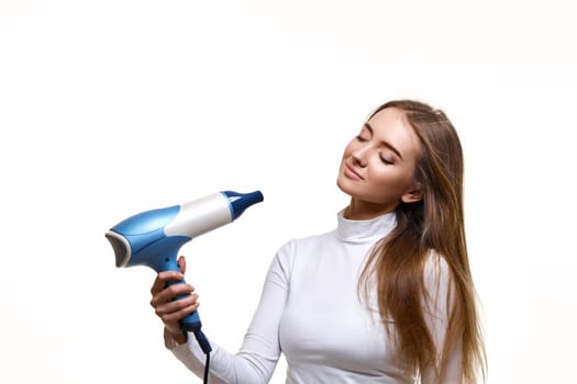 Portrait of attractive cheerful girl drying long hair isolated on white background