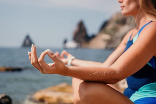 Woman sea yoga. Back view of free calm happy satisfied woman with long hair standing on top rock with yoga position against of sky by the sea. Healthy lifestyle outdoors in nature, fitness concept.