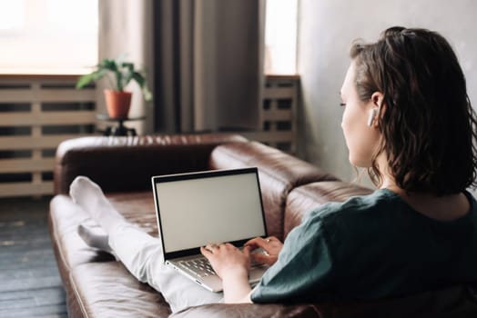 Young Woman Engages with Laptop at Home. Embrace the Potential of Freelancing, Student Lifestyle, Education, Web Conferencing, Video Calls, Technology, and Online Shopping with a Blank White Screen.
