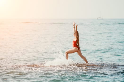 Woman sea yoga. Back view of free calm happy satisfied woman with long hair standing on top rock with yoga position against of sky by the sea. Healthy lifestyle outdoors in nature, fitness concept.