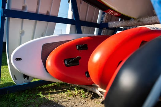 Yellow and white surfboards lie on the beach. Leisure. Yoga on sup board with paddle