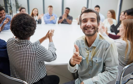 Smiling business group of office workers, executive board members or employees looking at camera sitting at conference table