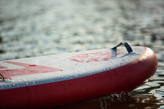 Close up of a stand up paddle board SUP and paddle on a dock on water