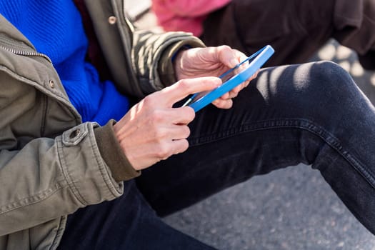 close up of the hand of a young person using mobile phone to scroll through social media, concept of technology of communication and modern lifestyle
