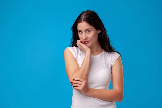 Thoughtful attractive young woman thinking on the blue background