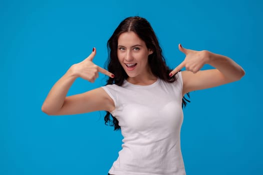Woman making gun gesture on the blue background