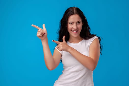 Woman making gun gesture on the blue background