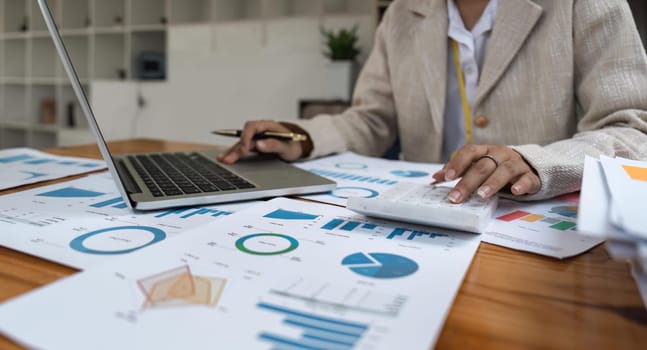 Close-up of businesswoman hands using a calculator to check company finances and earnings and budget. Business woman calculating monthly expenses, managing budget, papers, loan documents, invoices.