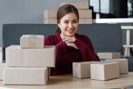 Woman owner of a startup company selling products online on an online store, sending goods through a courier company, Business planning. Online selling and online shopping concepts.