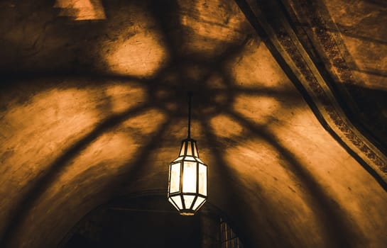 light from the lamp on the ceiling and the shadows in the mysterious arch